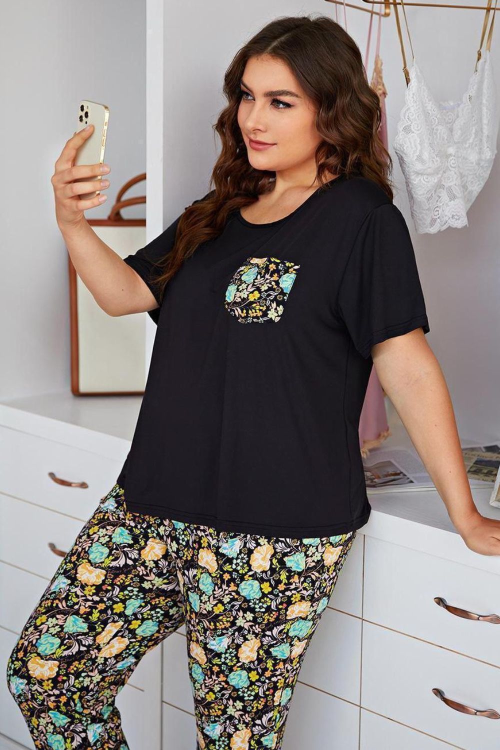 Trendsi plus size lounge set featuring a black top with floral pocket and matching floral pants