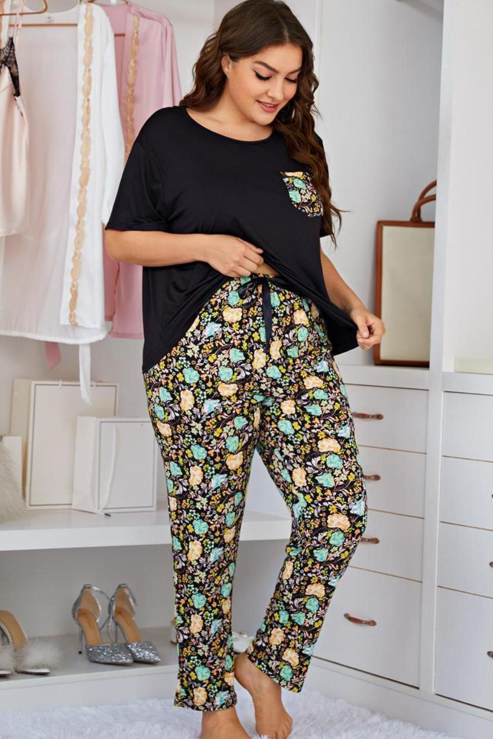 Trendsi plus size lounge set featuring a black top with floral pocket and matching floral print pants