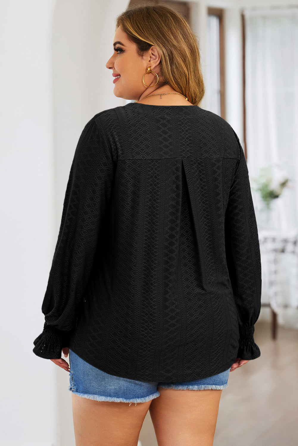 Plus size trendy blouse for women in black textured fabric with long sleeves and smocked cuffs