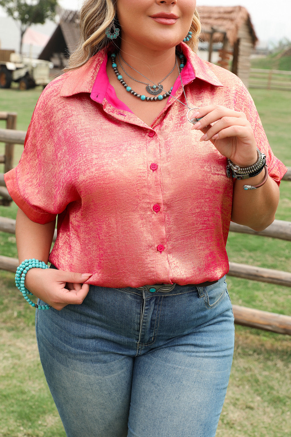 Rose red plus size metallic shirt worn with blue jeans and turquoise jewelry outdoors