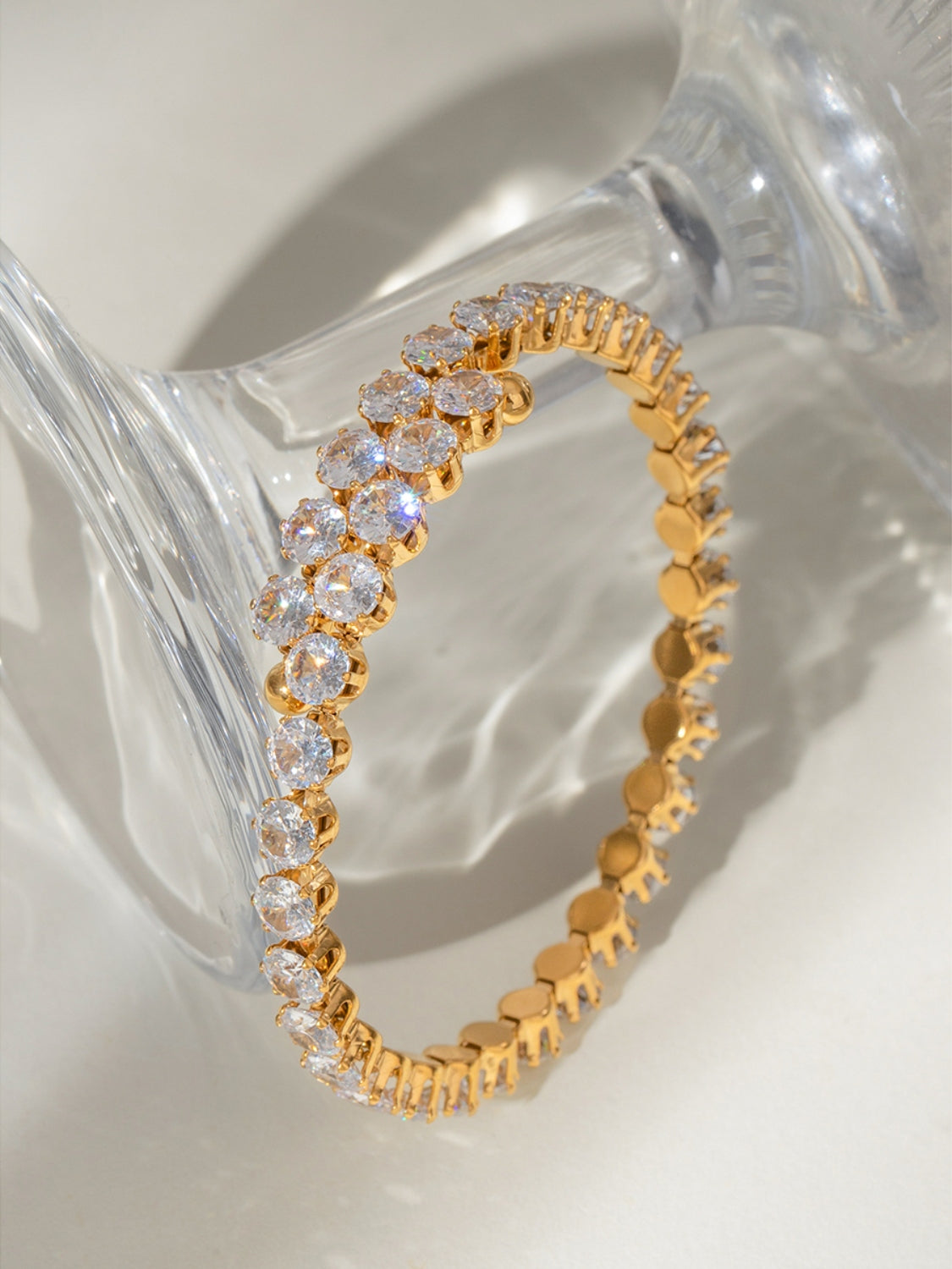 Trendsi gold stainless steel zircon bracelet with clear sparkling stones on a glass surface