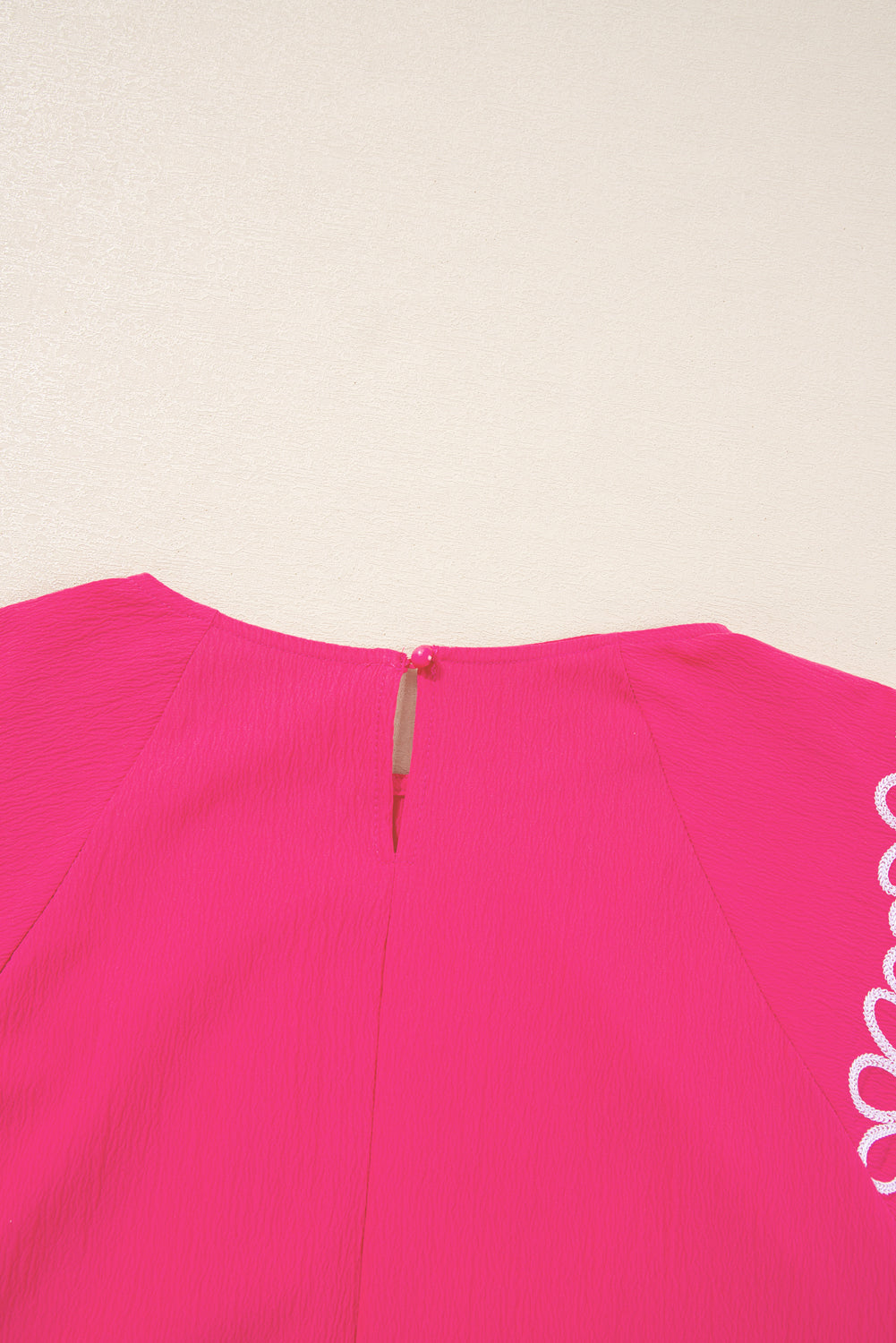 Back view of strawberry pink embroidered blouse from kjplussizefashion with keyhole button closure