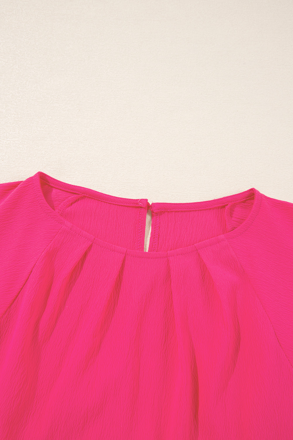 Strawberry pink embroidered blouse close-up showing neckline and fabric texture in plus size