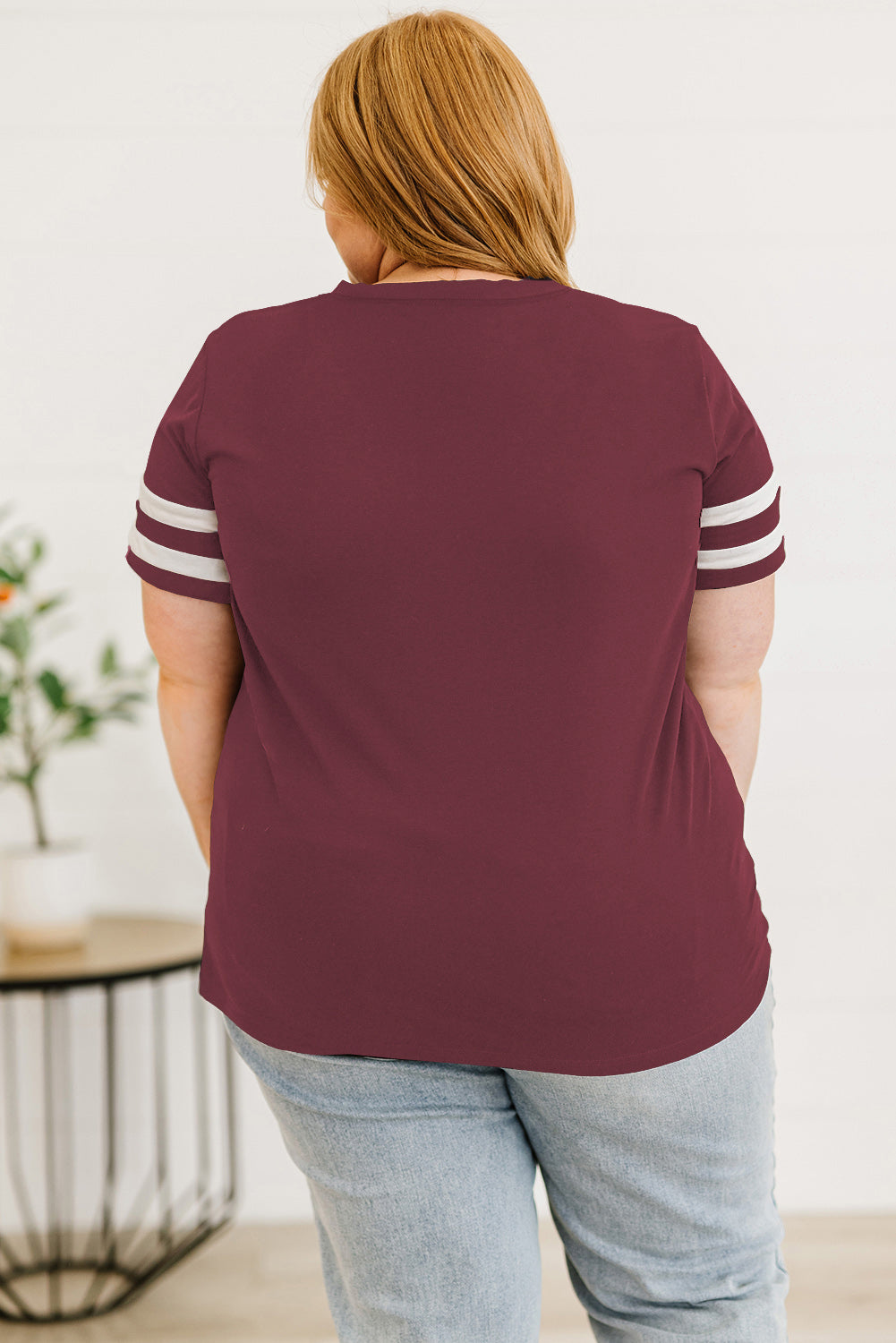 Back view of women's plus size striped sleeve top in maroon with white stripes on sleeves