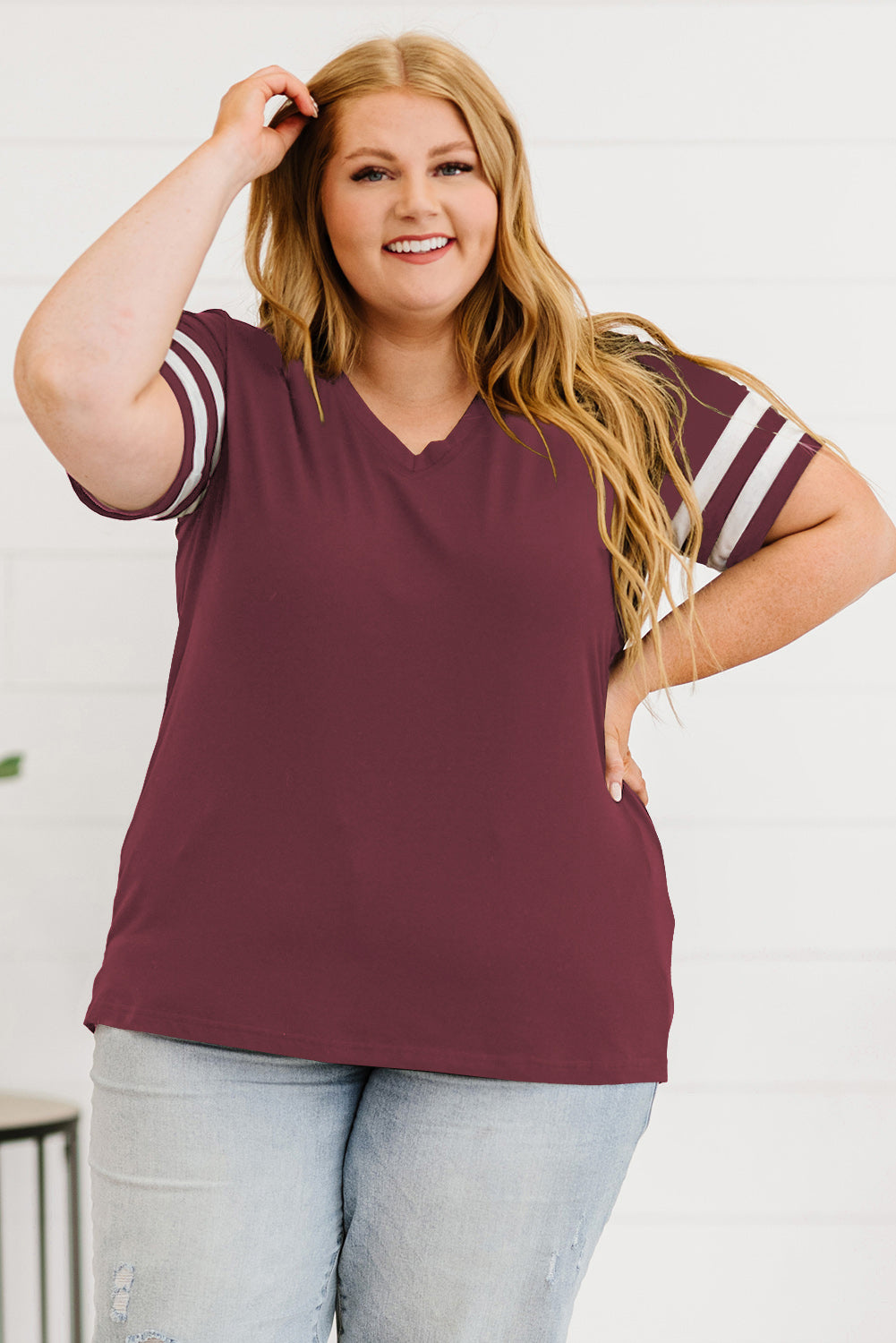 Trendsi women's plus size striped sleeve top in maroon with white stripes on sleeves paired with light wash jeans
