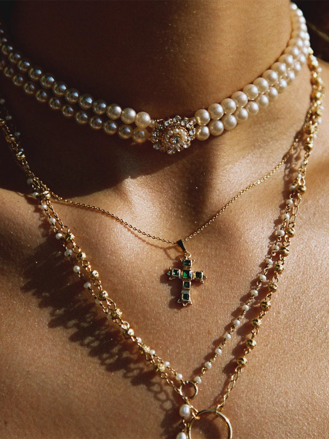 Zircon cross pendant for women on gold chain necklace layered with pearl choker and gold beaded necklace
