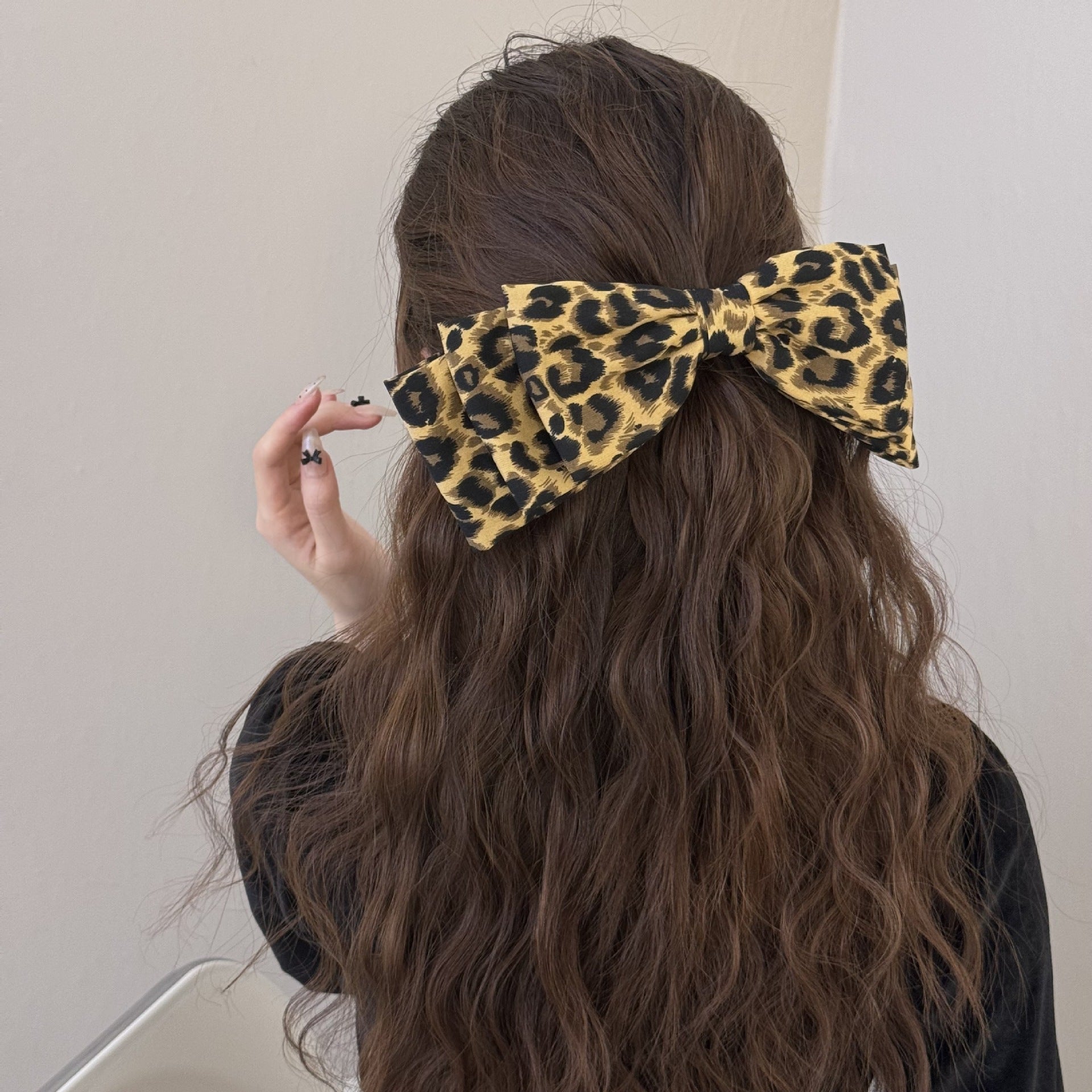 Trendsi 2 piece leopard print hair clips styled on long wavy brown hair with a bow shape