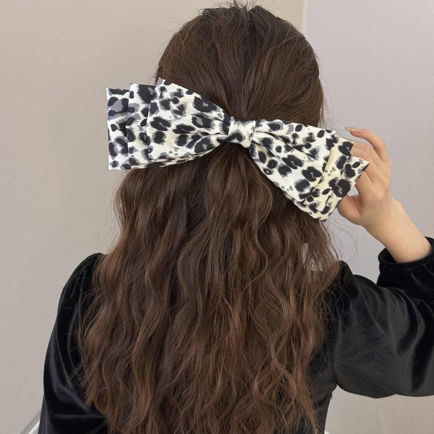 2 piece leopard print hair clips worn on long wavy brown hair with black top by Trendsi