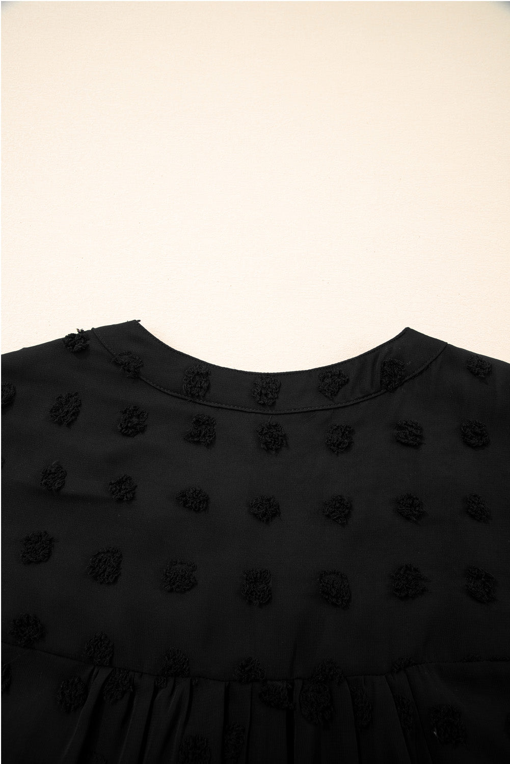 Close-up of black dotty plus size summer dress fabric with textured dot pattern by kjplussizefashion