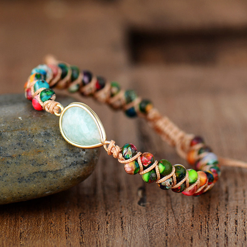 Trendsi blue gemstone teardrop bracelet with colorful beads and gold-tone setting on wooden surface