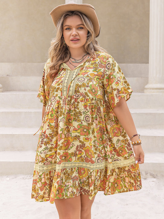 Trendsi plus size printed mini dress with floral pattern and loose fit worn with a tan hat