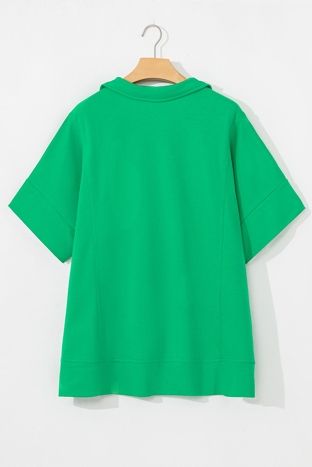 Bright green short sleeve blouse for women displayed on hanger with a relaxed fit and collar