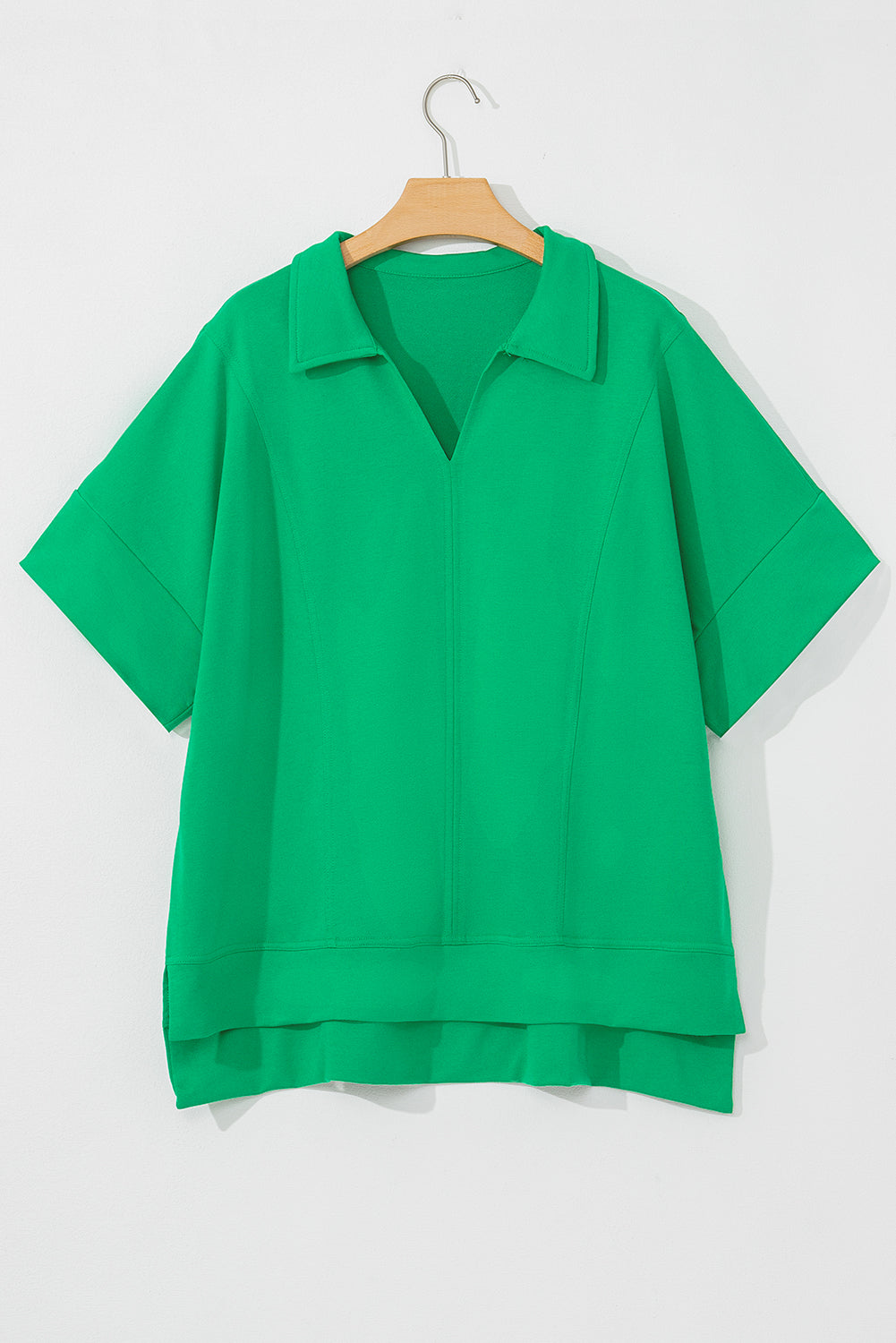 Bright green short sleeve blouse for women with collar and relaxed fit on wooden hanger