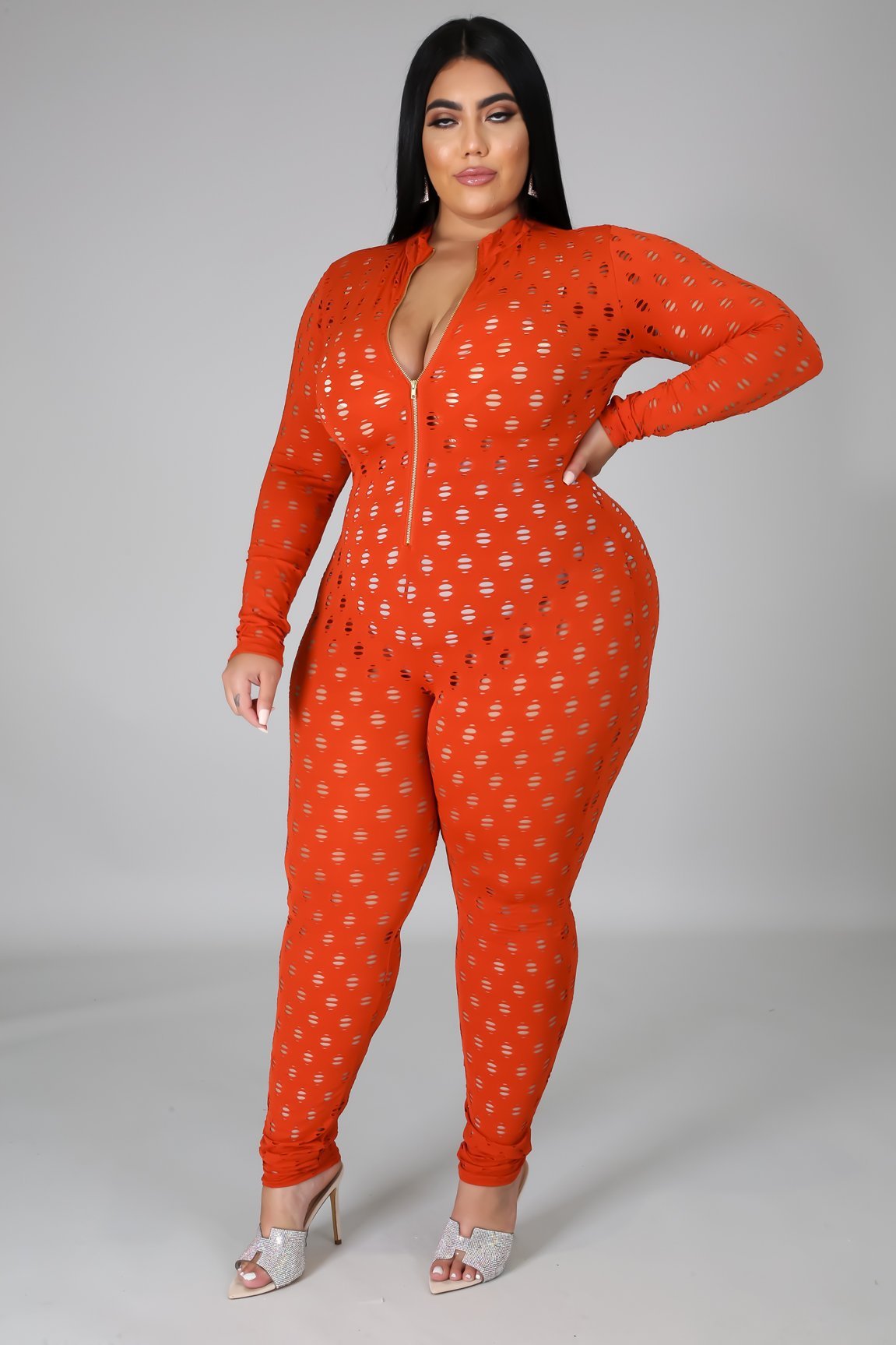 Curvy women zip front jumpsuit in orange with long sleeves and small white patterns