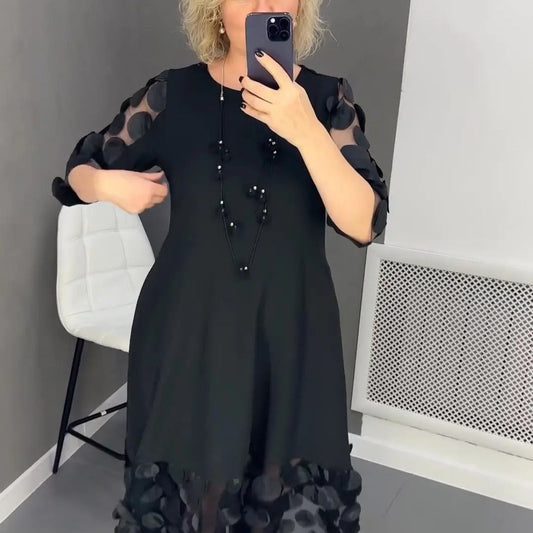 Elegant black dress for curvy women with sheer polka dot sleeves and hem detail