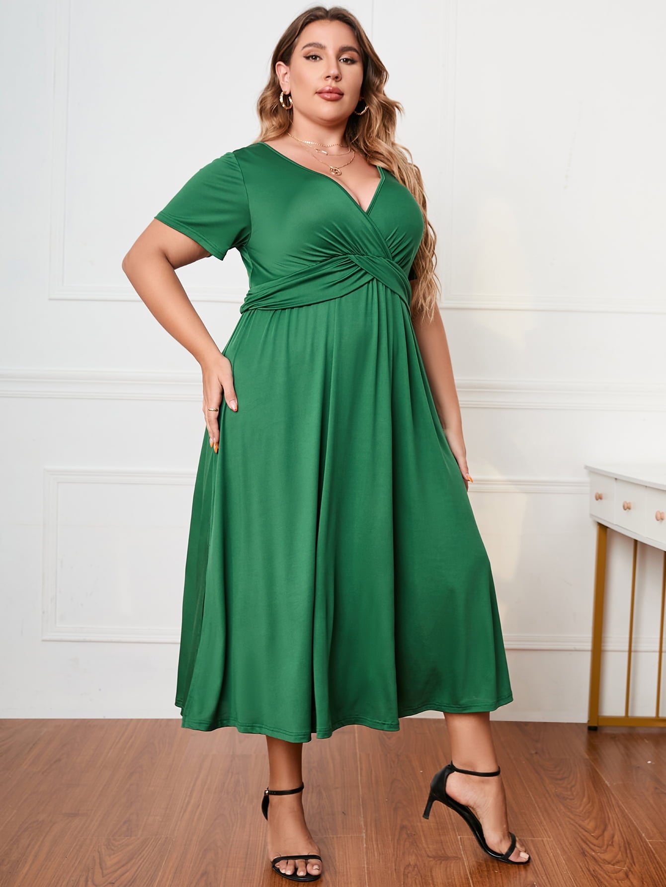 Green plus size short sleeve dress with V-neck and gathered waist worn by woman with black heels