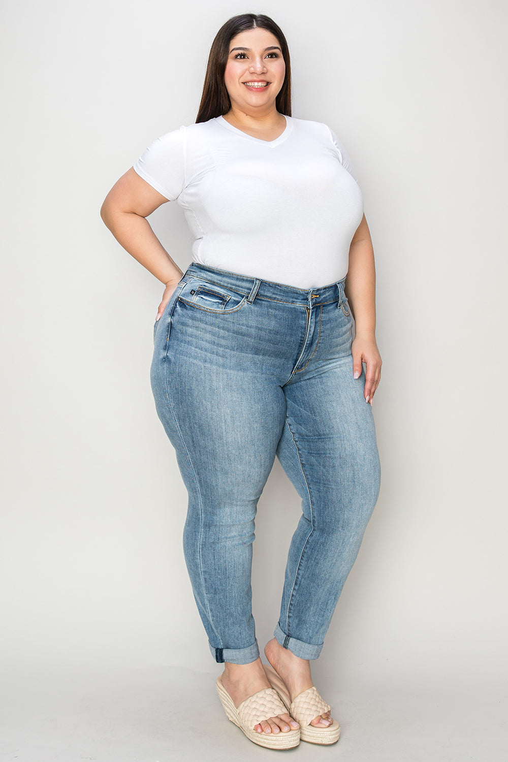 Plus size model wearing plus size cuffed hem jeans in light blue denim with a white t-shirt