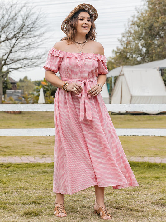 Plus size plaid off-shoulder short sleeve midi dress in pink with waist tie and ruffled neckline worn outdoors