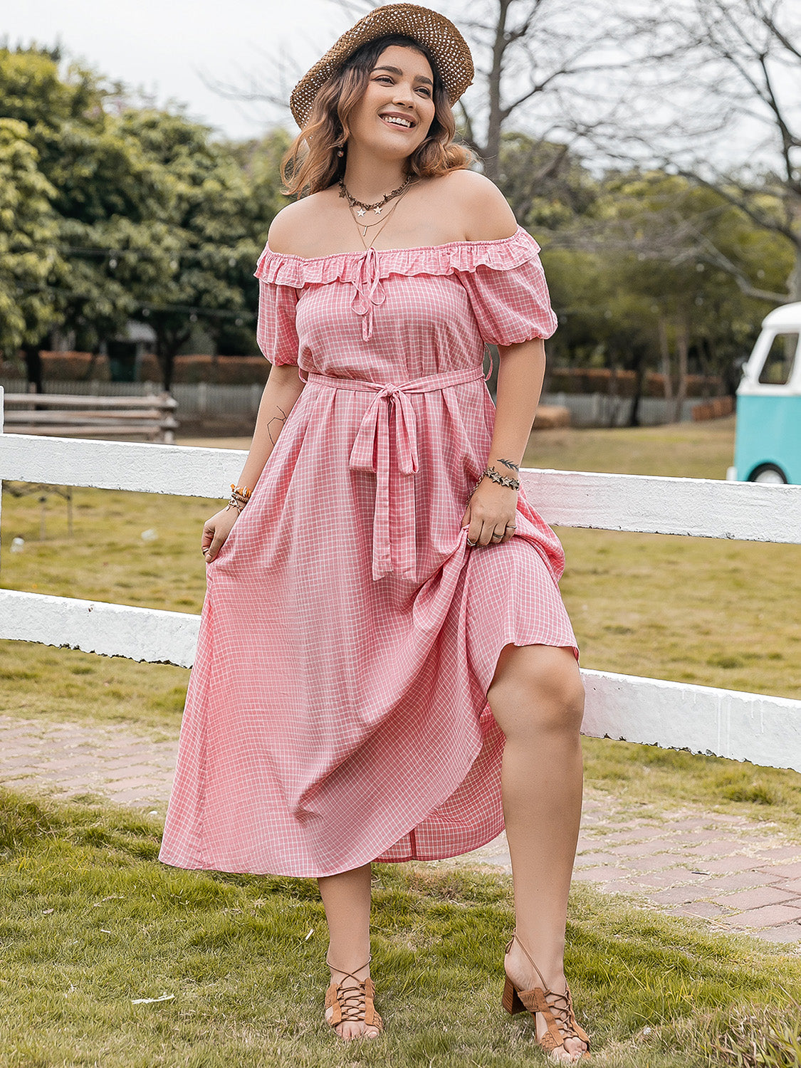 Plus size plaid off-shoulder short sleeve midi dress in pink with adjustable waist tie and elastic neckline worn outdoors