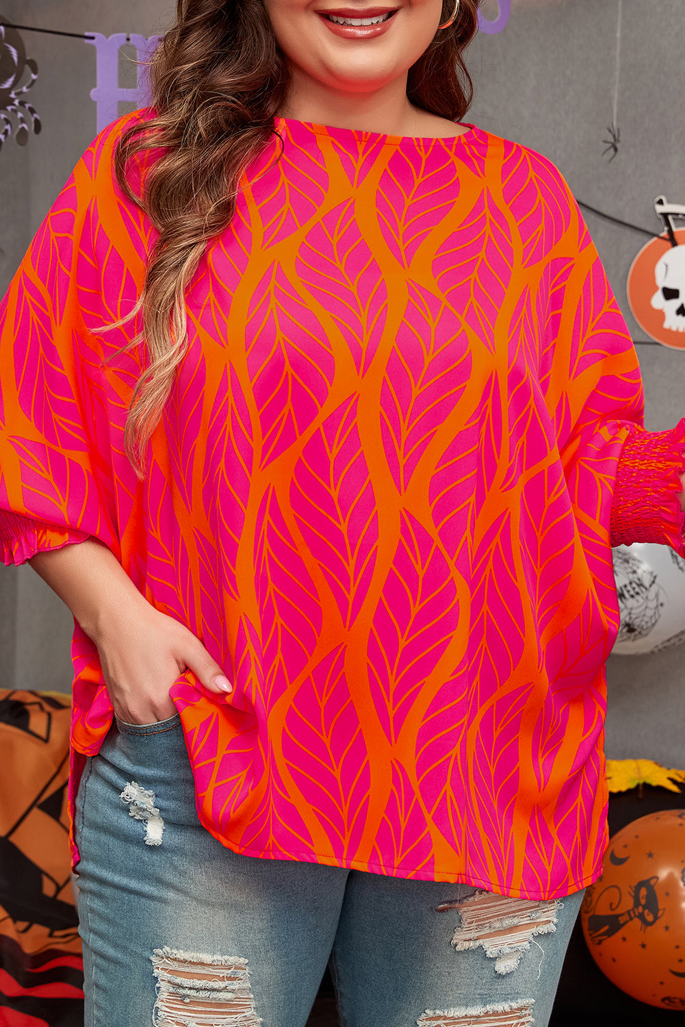 Plus size rose print blouse in vibrant pink and orange leaf pattern worn with distressed jeans