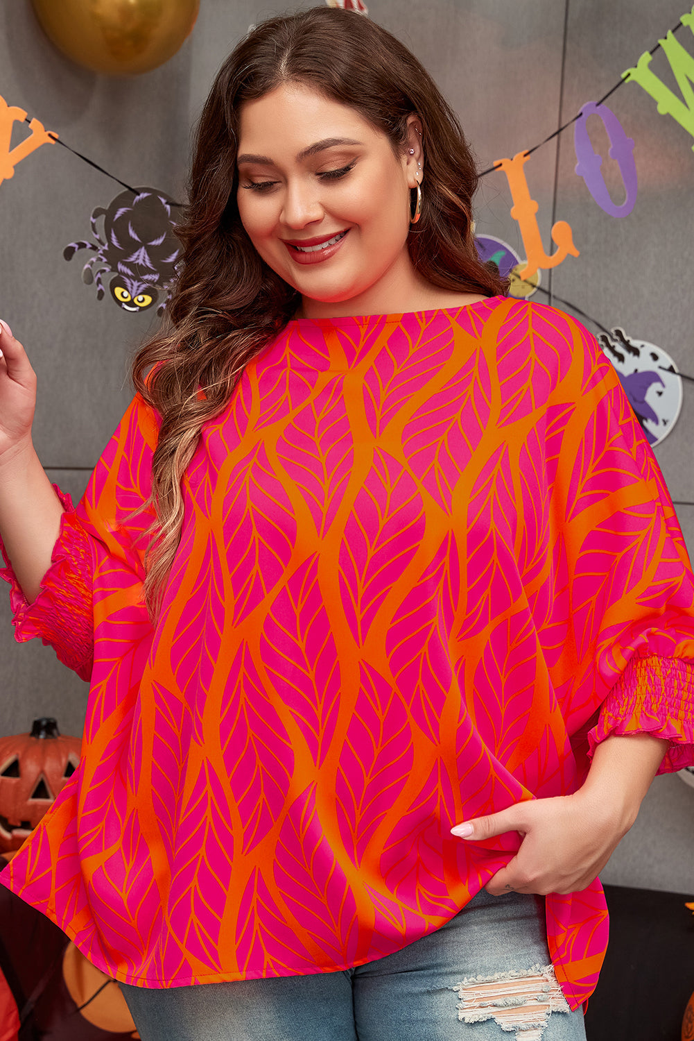 Plus size rose print blouse with vibrant pink and orange leaf design worn by smiling woman