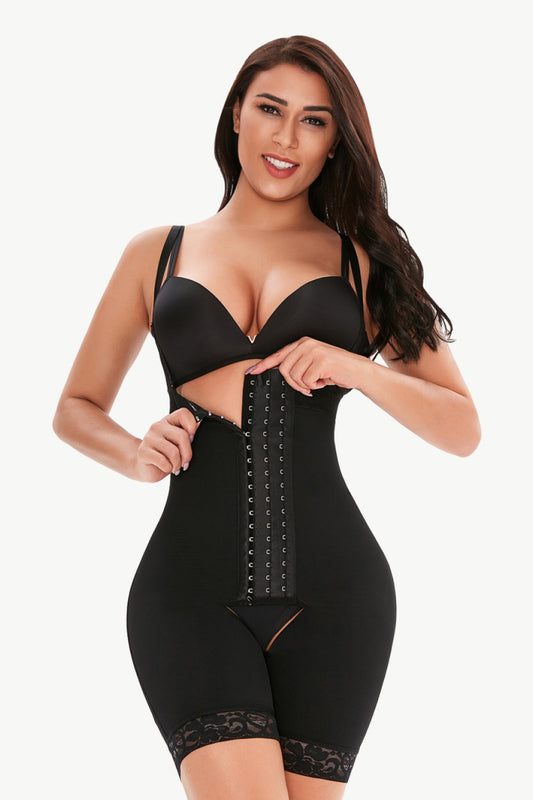 Woman wearing black plus size shaping bodysuit with front hook-and-eye closure and adjustable straps