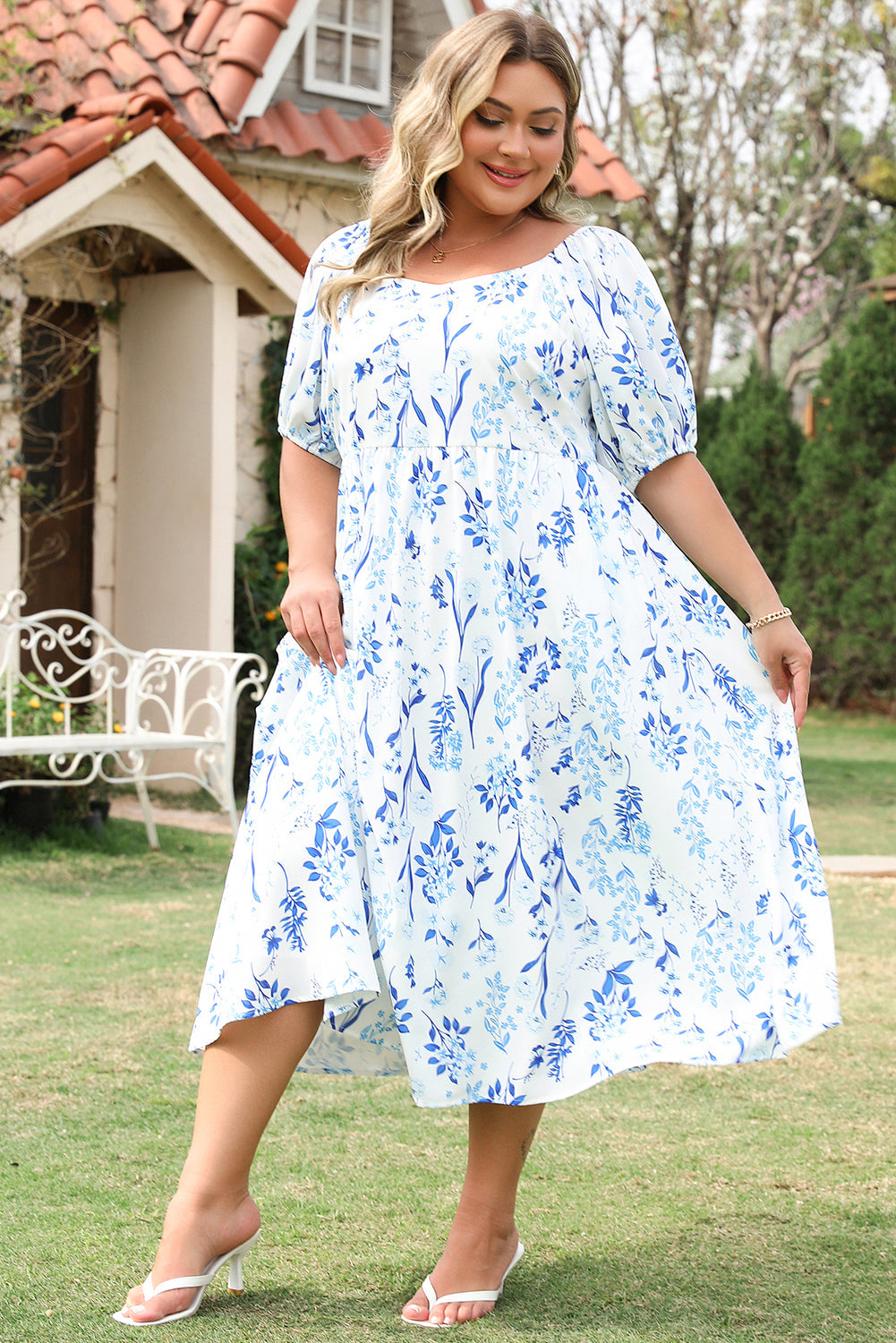 Plus size sky blue floral midi dress with puff sleeves and flowy skirt styled outdoors