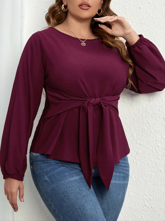Plus size tie front blouse in dark purple with long sleeves and round neckline styled with blue jeans