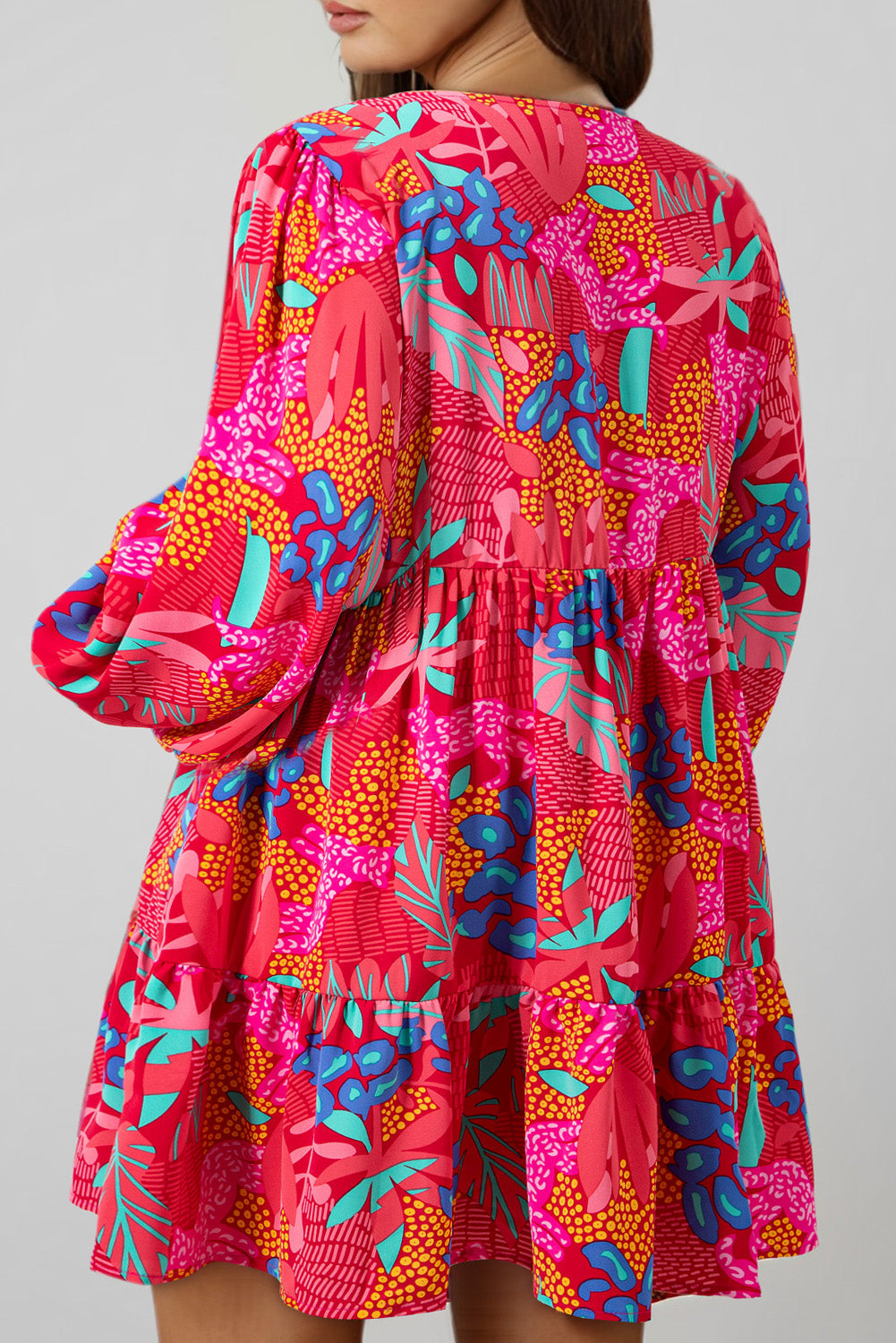 Back view of plus size tropical print mini dress with vibrant colors and long puff sleeves