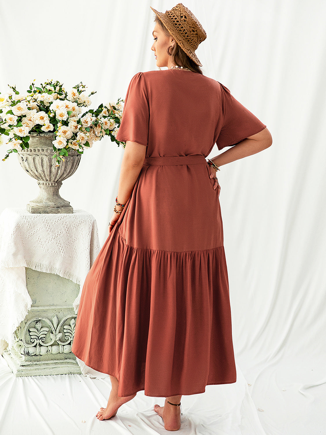 Trendsi plus size v neck midi dress in rust color with short sleeves and a cinched waist seen from the back