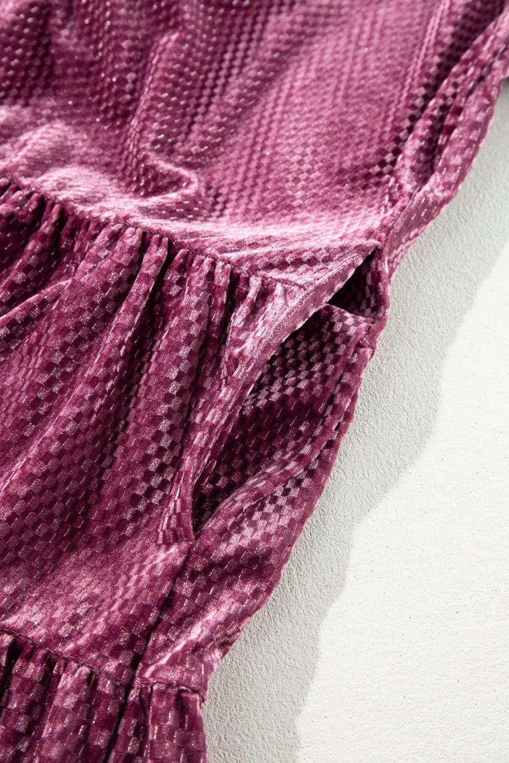 Close-up of textured velvet dress for curvy women in rich purple color showing fabric details and pocket