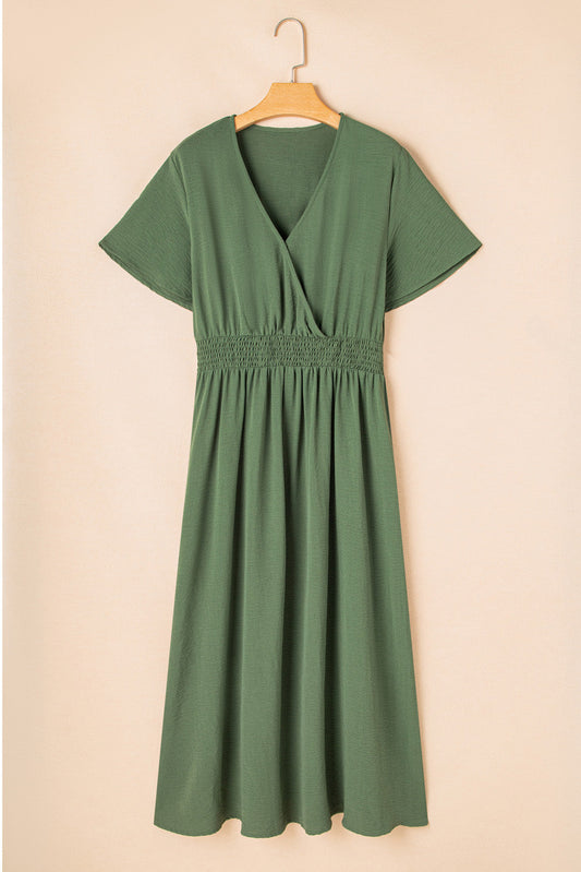 Plus size four leaf clover shirred waist dress in green with short sleeves on a hanger