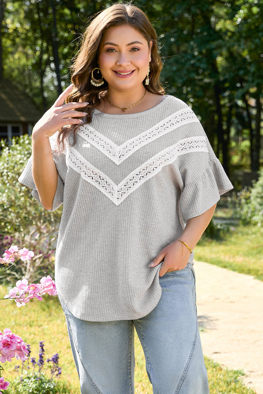Plus size model wearing light grey ruffle sleeve blouse with lace details outdoors from kjplussizefashion