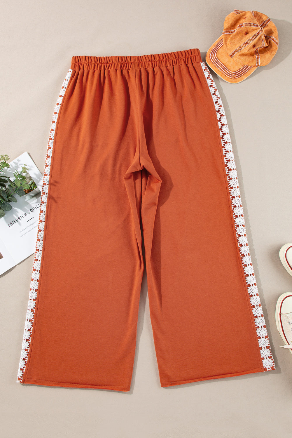 Plus size rust orange wide leg pants with drawstring and pockets featuring white patterned side stripes